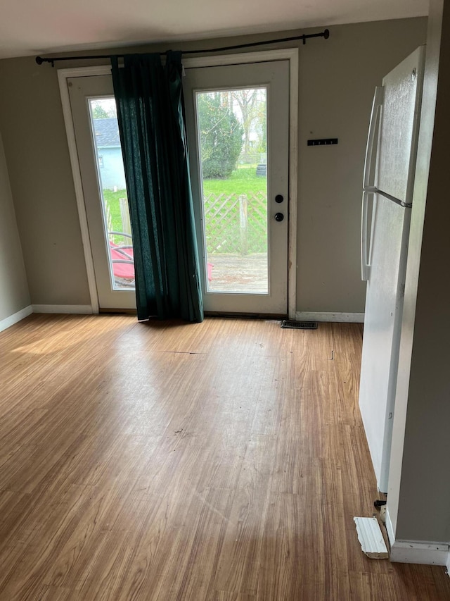 interior space featuring baseboards, visible vents, wood finished floors, and a wealth of natural light
