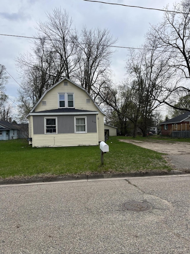 view of front of house with a gambrel roof and a front yard
