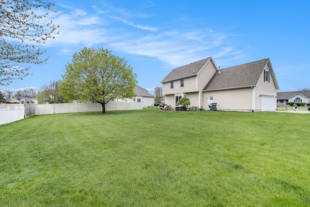 view of yard with fence and a garage