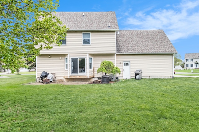 rear view of property with a lawn, roof with shingles, and central air condition unit
