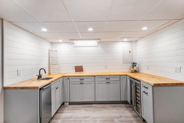 kitchen featuring a sink, butcher block countertops, a drop ceiling, wine cooler, and gray cabinetry