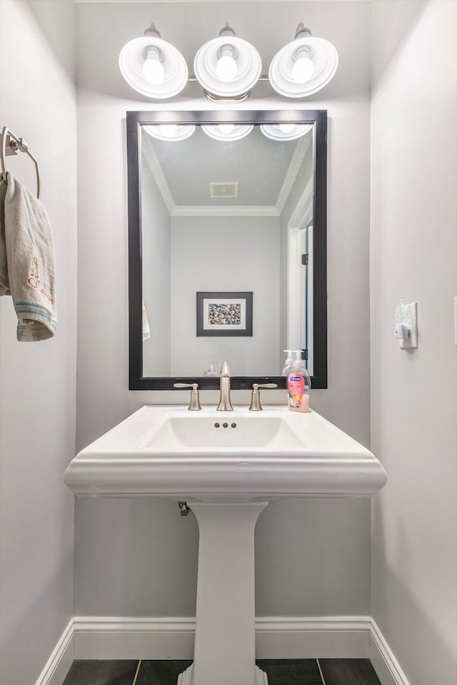 bathroom featuring crown molding, baseboards, visible vents, and tile patterned flooring