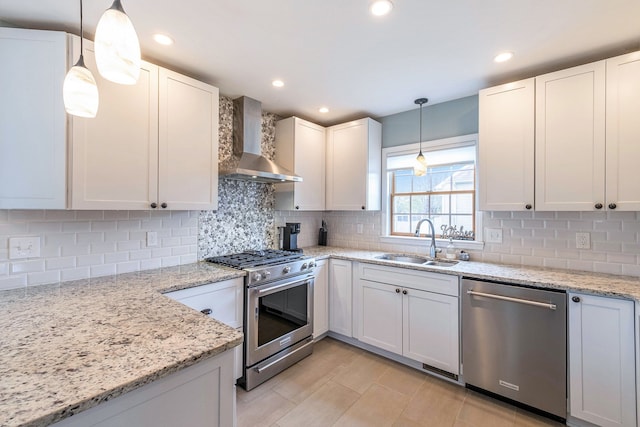 kitchen featuring appliances with stainless steel finishes, a sink, wall chimney exhaust hood, and tasteful backsplash