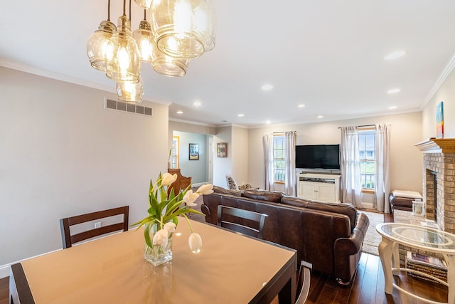 dining space featuring visible vents, a fireplace, dark wood finished floors, an inviting chandelier, and recessed lighting