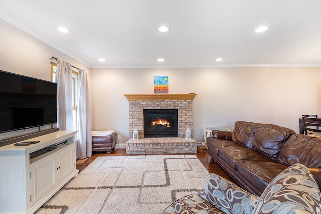 living room with recessed lighting, crown molding, a brick fireplace, and wood finished floors