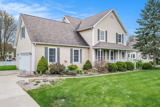 traditional-style house with covered porch, concrete driveway, a front yard, and a garage