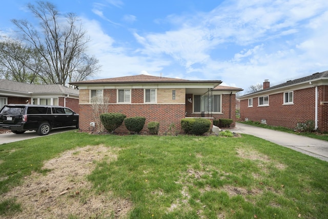 view of front of home with brick siding, driveway, and a front yard
