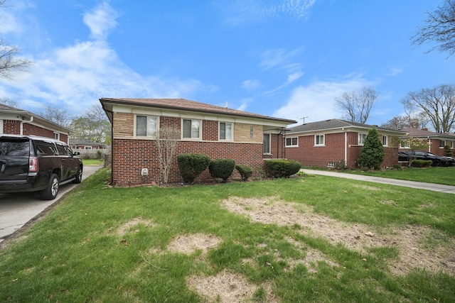 bungalow with brick siding and a front lawn