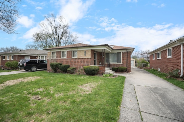 view of front of property with driveway, a front lawn, and brick siding
