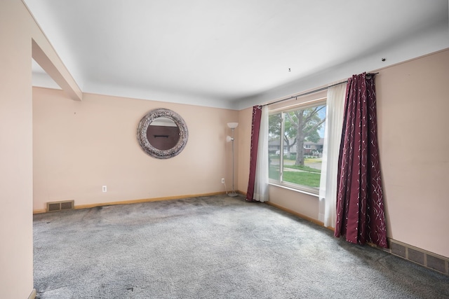 carpeted spare room with visible vents and baseboards