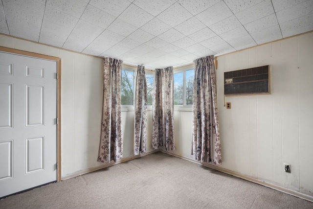carpeted empty room featuring an AC wall unit
