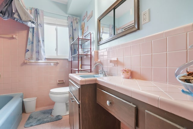 bathroom featuring toilet, a washtub, tile walls, and vanity