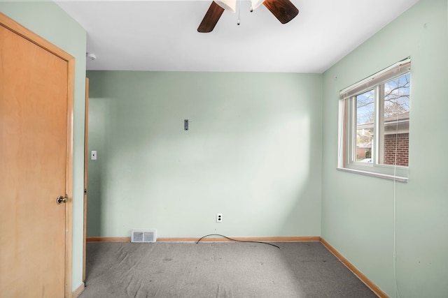 carpeted empty room with baseboards, a ceiling fan, and visible vents