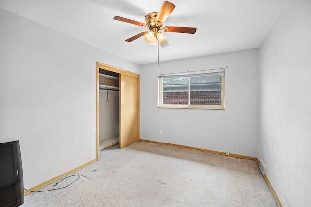 unfurnished bedroom with a ceiling fan, baseboards, carpet, and a closet