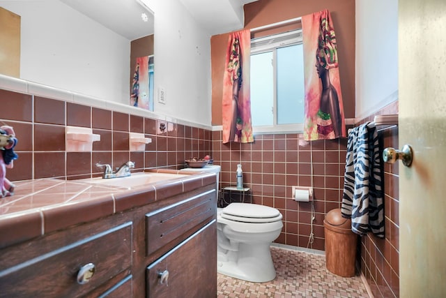 bathroom featuring tile walls, vanity, and toilet
