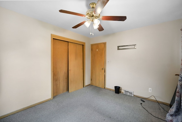 unfurnished bedroom featuring carpet floors, visible vents, a closet, baseboards, and a ceiling fan