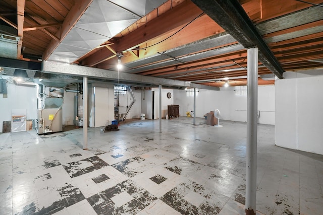 unfinished basement with tile patterned floors, heating unit, and water heater