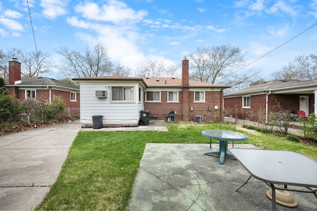 rear view of house with a yard, fence, a chimney, and a patio area