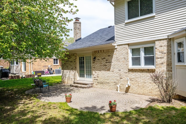 44492 Midway Dr, Novi, MI 48375 - doorway to property with central AC unit, a patio, brick siding, a chimney, and a yard