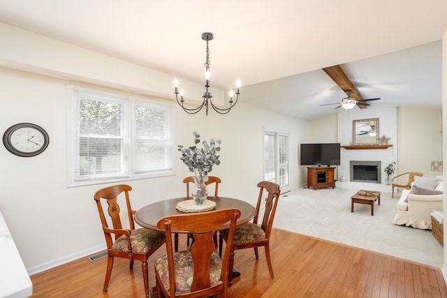 44492 Midway Dr, Novi, MI 48375 - dining space with light wood-type flooring, a chandelier, a large fireplace, and baseboards