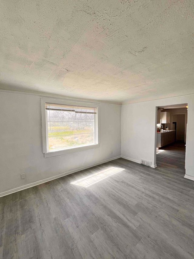 17421 Oakland St, Highland Park, MI 48203 - empty room with a textured ceiling, dark wood finished floors, and baseboards