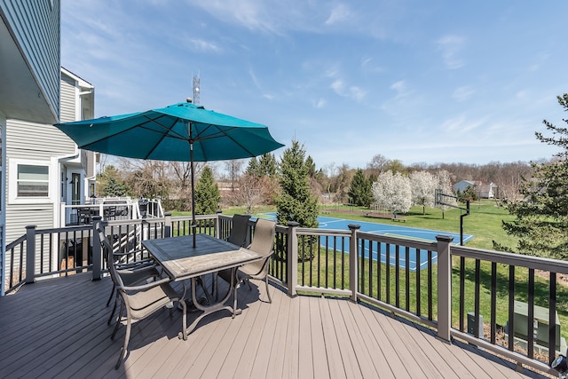 deck with a lawn and outdoor dining area