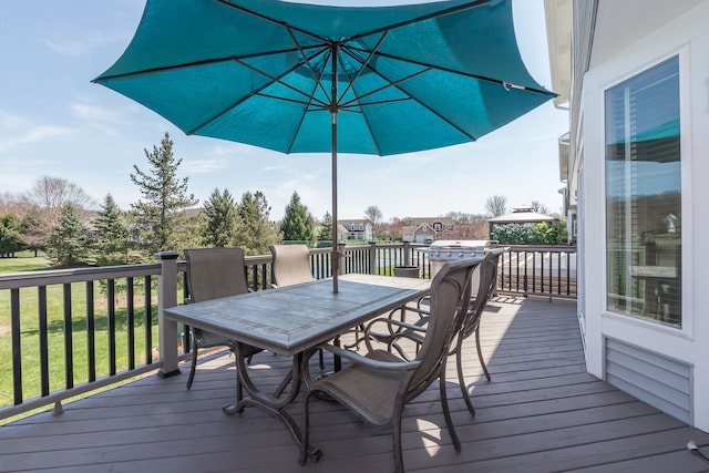 wooden terrace featuring a lawn and outdoor dining area