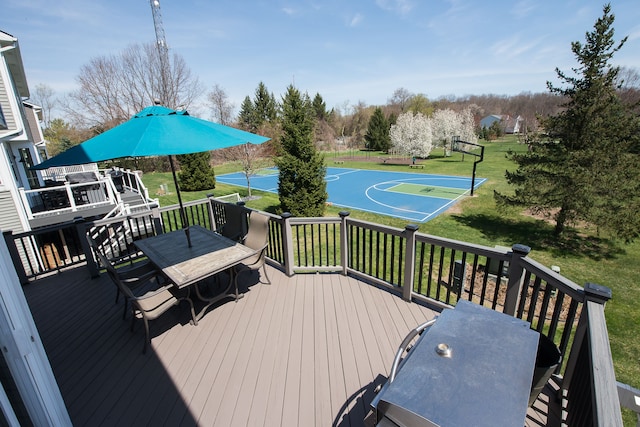 wooden terrace with basketball hoop, a yard, and outdoor dining area