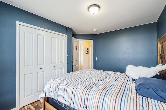 bedroom with wood finished floors and a closet