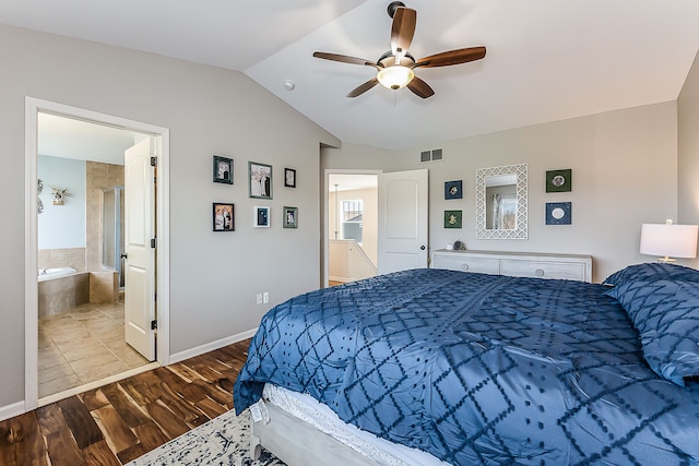 bedroom with lofted ceiling, visible vents, baseboards, wood finished floors, and ensuite bathroom