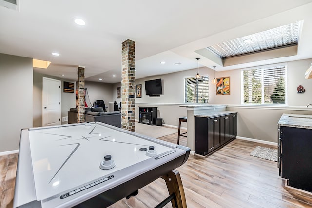 playroom featuring decorative columns, recessed lighting, light wood-style flooring, and baseboards