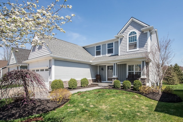 traditional-style home with a front lawn, a garage, a shingled roof, covered porch, and board and batten siding