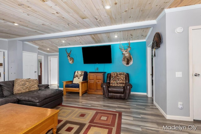 living room with wood finished floors, ornamental molding, and baseboards