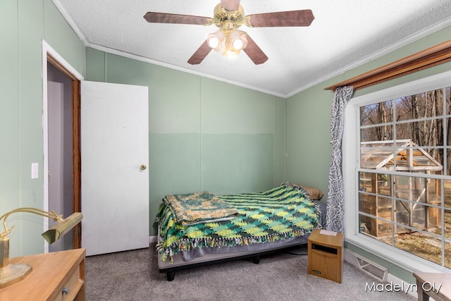 carpeted bedroom featuring multiple windows, visible vents, a ceiling fan, a textured ceiling, and crown molding