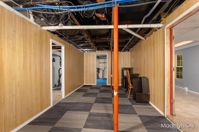 unfinished basement with a baseboard radiator, carpet, and baseboards