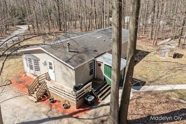 exterior space featuring roof with shingles, central AC, and entry steps