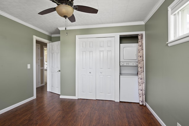 unfurnished bedroom with baseboards, stacked washer / dryer, and wood finished floors