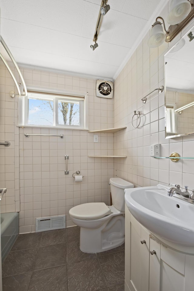 bathroom featuring toilet, tile walls, visible vents, and vanity
