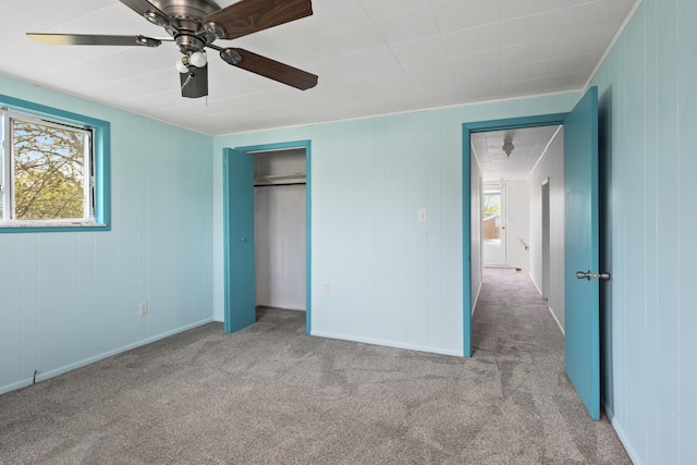 unfurnished bedroom with a closet, ceiling fan, and carpet floors