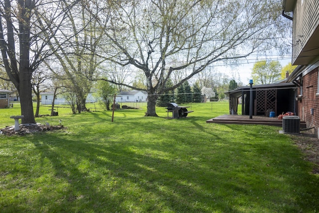 view of yard with cooling unit, a deck, and fence