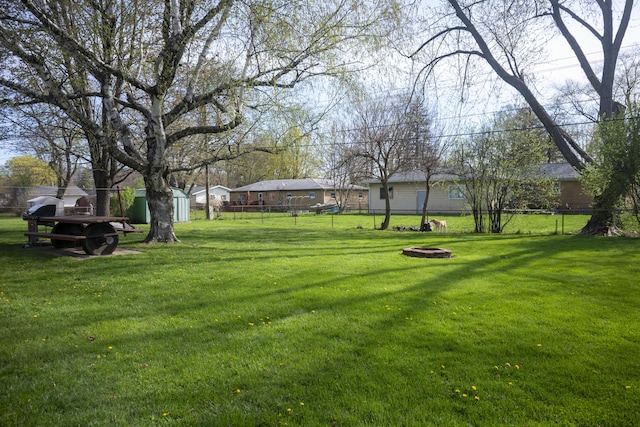 view of yard with fence, an outbuilding, and a storage shed