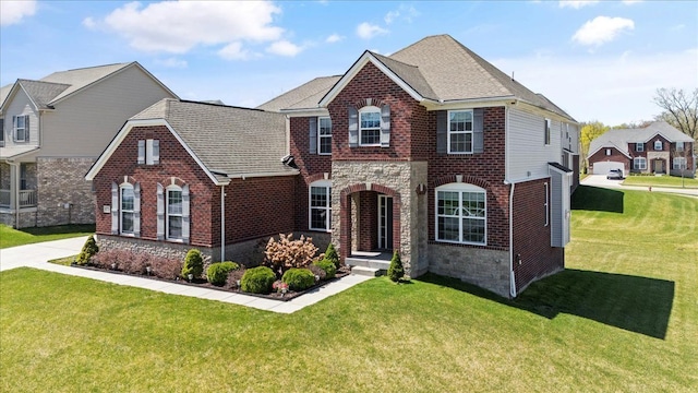 view of front of house featuring brick siding, a front lawn, and stone siding