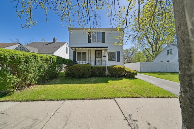 view of front facade with a porch, fence private yard, and a front lawn