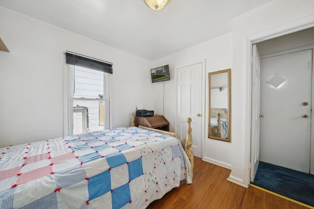 bedroom with baseboards and wood finished floors