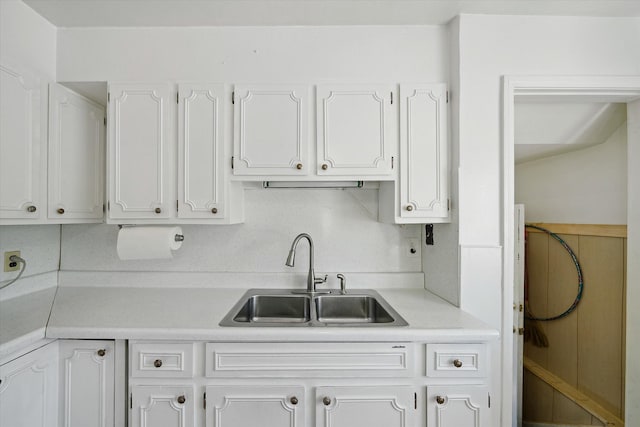 kitchen featuring a sink, light countertops, and white cabinets