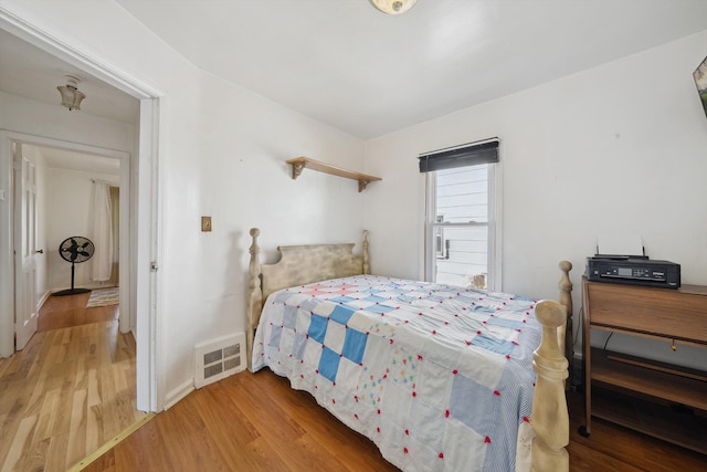 bedroom with visible vents, light wood-style floors, and baseboards