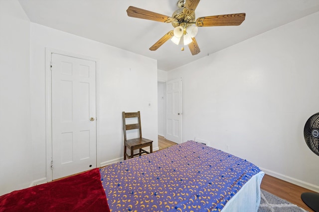 bedroom featuring baseboards, ceiling fan, and wood finished floors