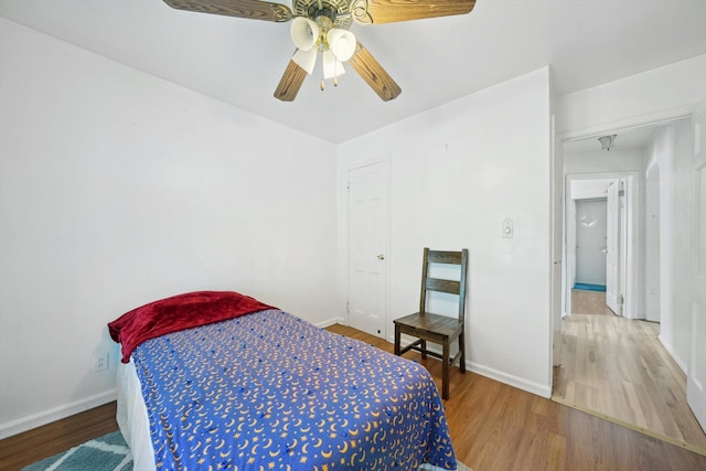 bedroom featuring baseboards, a ceiling fan, and wood finished floors