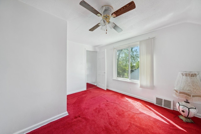 carpeted empty room with visible vents, a ceiling fan, and baseboards