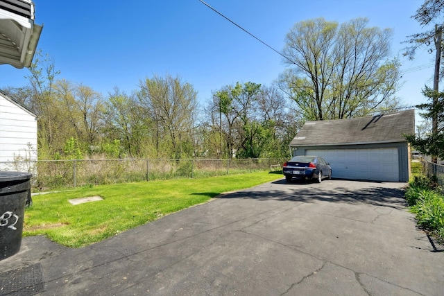 view of yard with fence, an outbuilding, and a garage